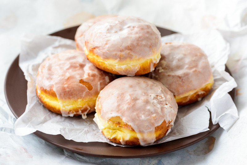 Polskie pączki zamiast posypywać cukrem pudrem ,częściej polewa się lukrem, również z dodatkiem skórki pomarańczowej.