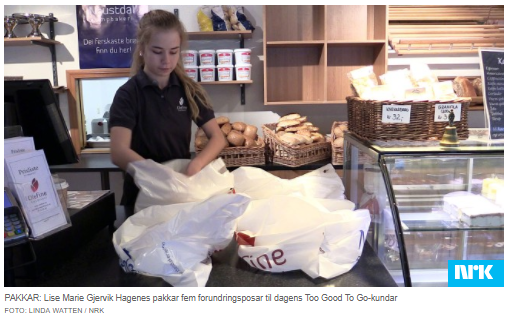 Pracownica piekarni przygotowuje produkty do kupienia przez aplikację.